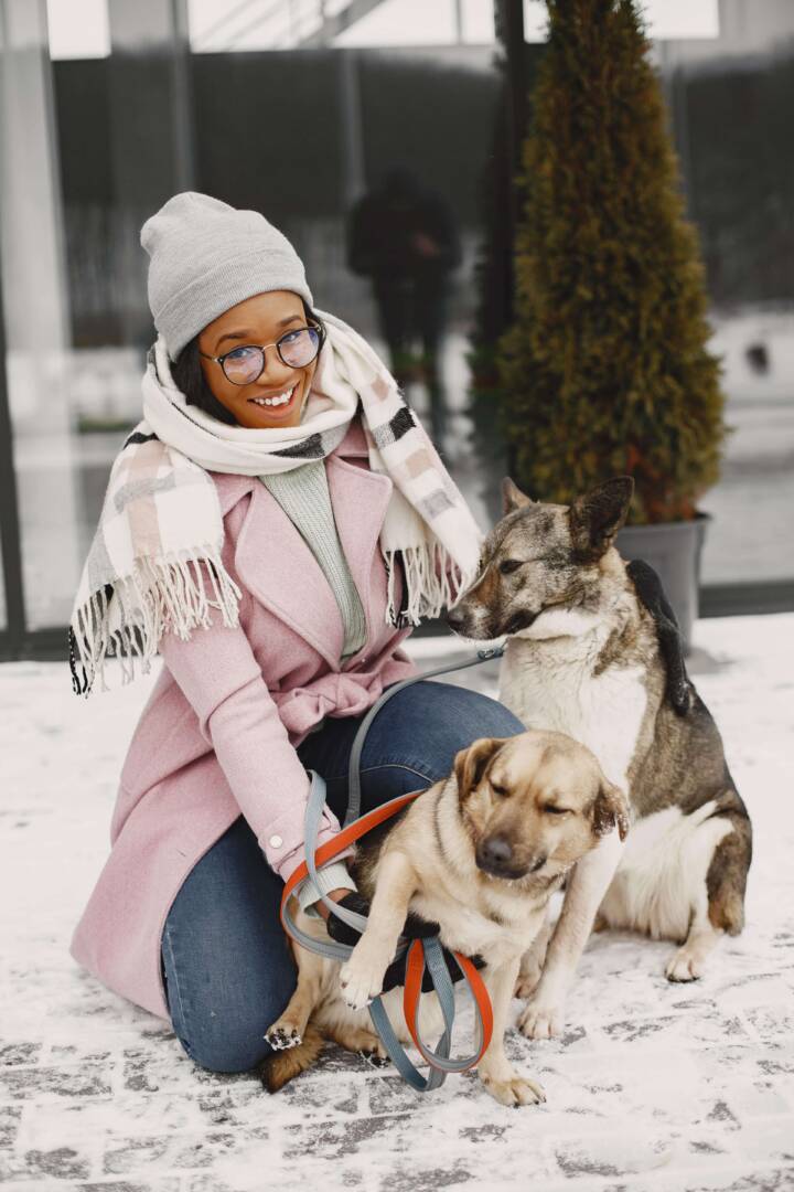woman posing wit two dogs outdoors