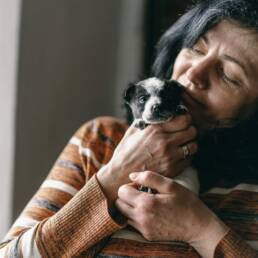 Woman holding a small black and white puppy.